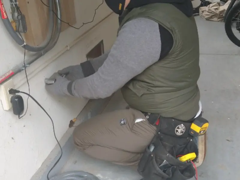 Electrician performing outlet wiring in a Sappington garage